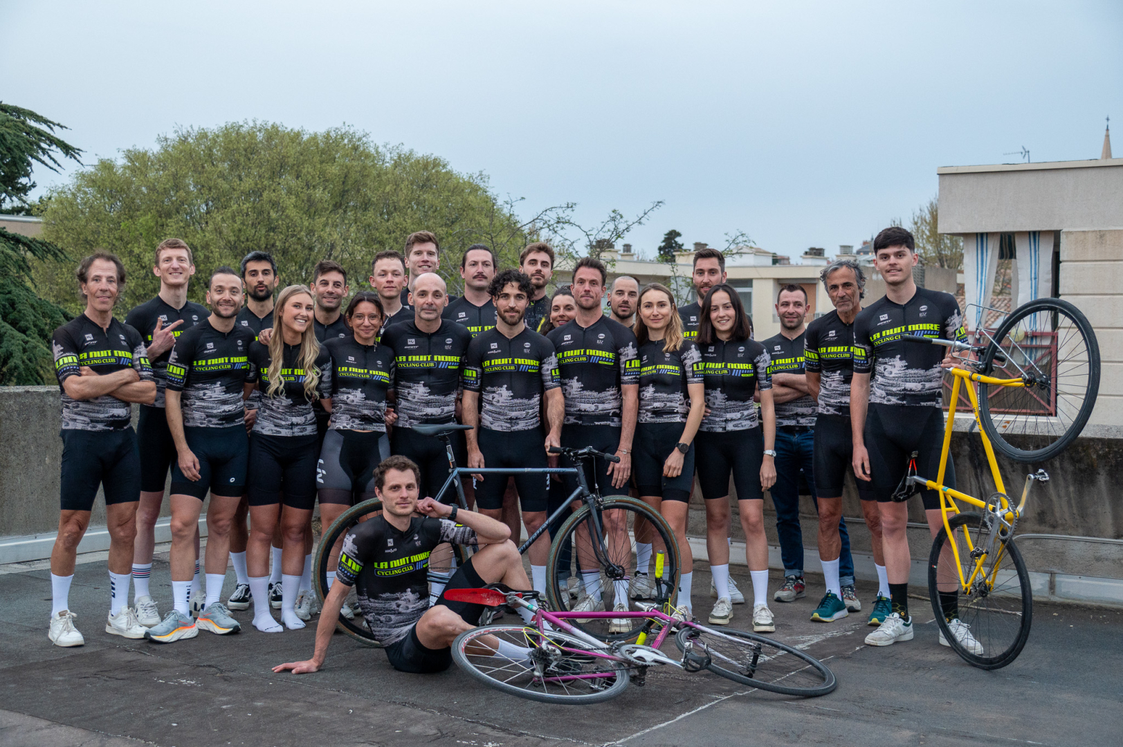 photo de groupe club La Nuit Noire Cycling avec maillots et vélos 