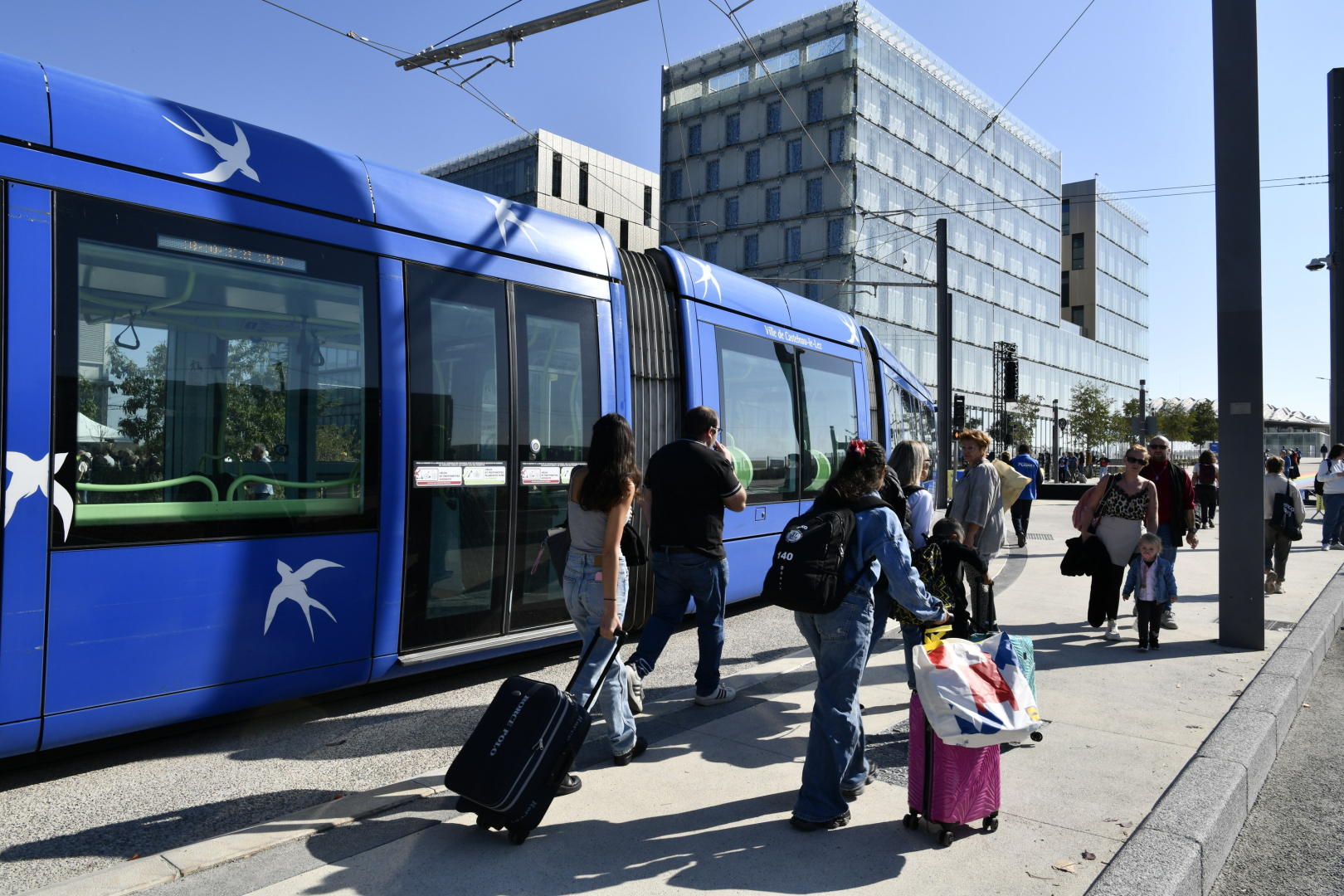 tramway voyageurs avec valises batiments parvis de la gare 