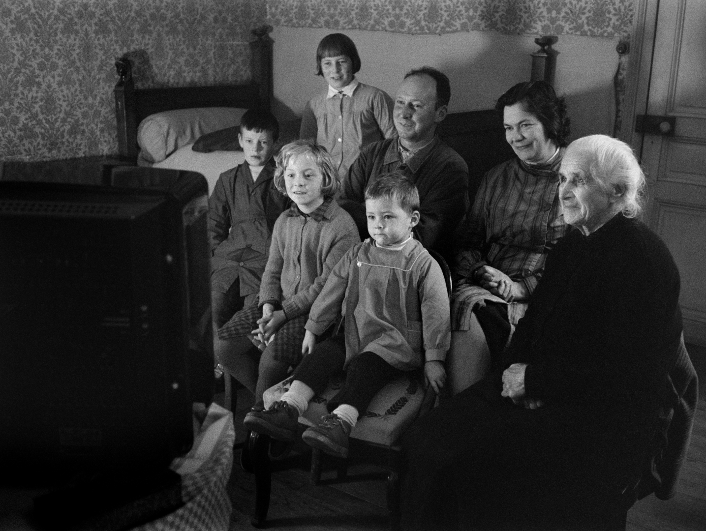 photo en noir et blanc de personnes qui regardent la télévision 